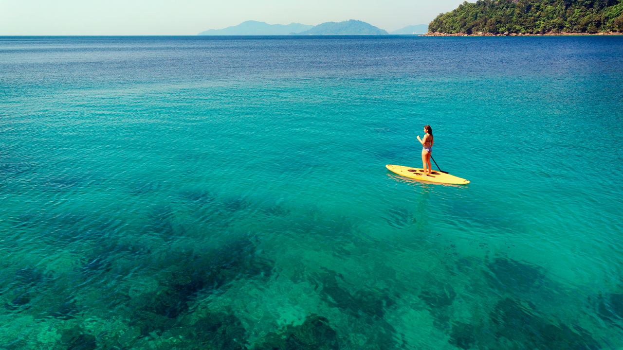 Woman paddle-boarding on a turquoise sea