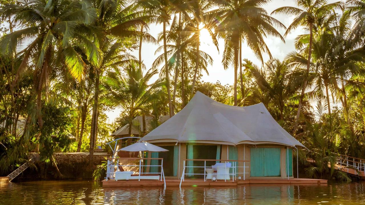Floating villa in front of palm trees at 4 Rivers Floating Lodge