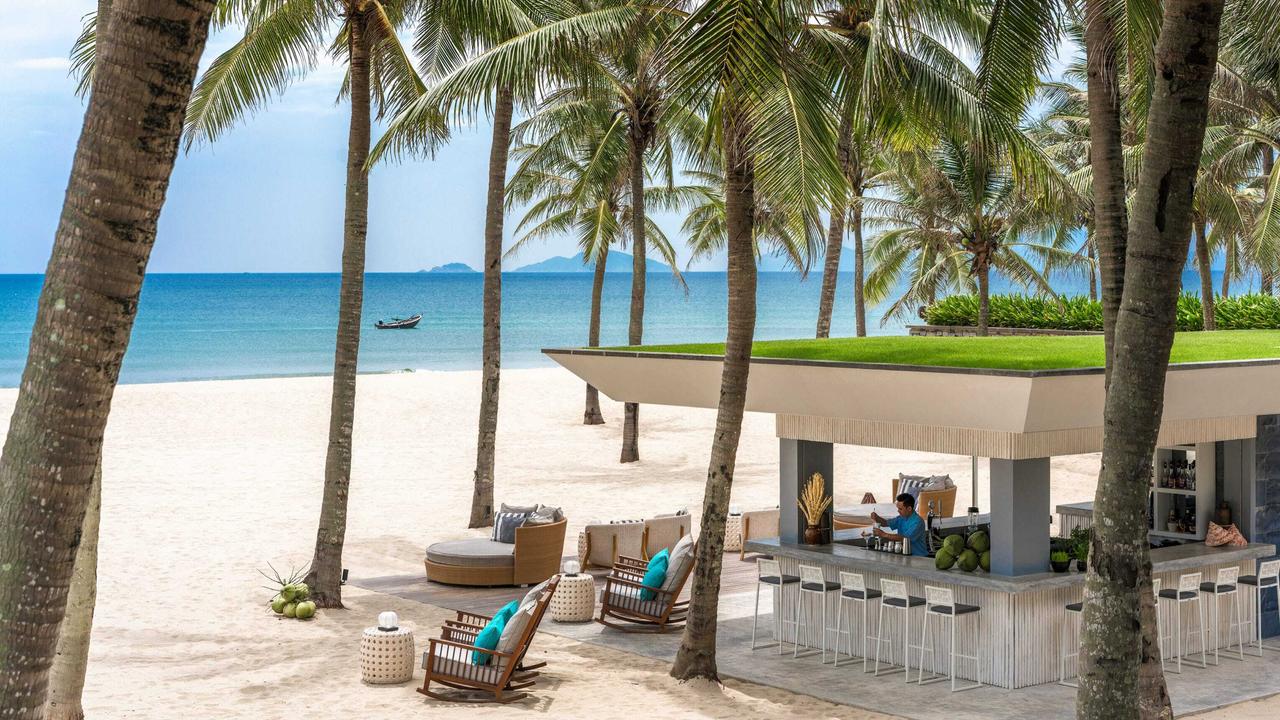 Beach bar with palm trees at Four Seasons Nam Hai Hoi An