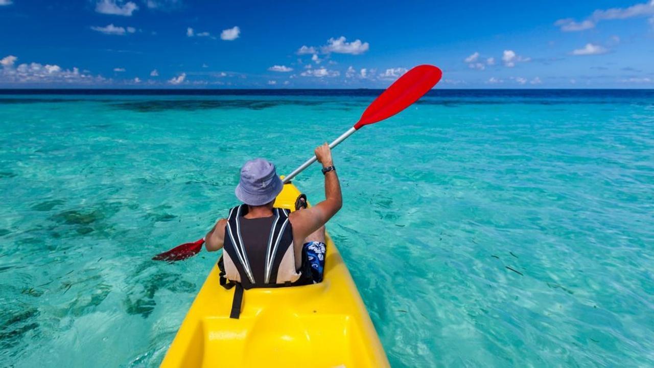 Man kayaking on a blue sea