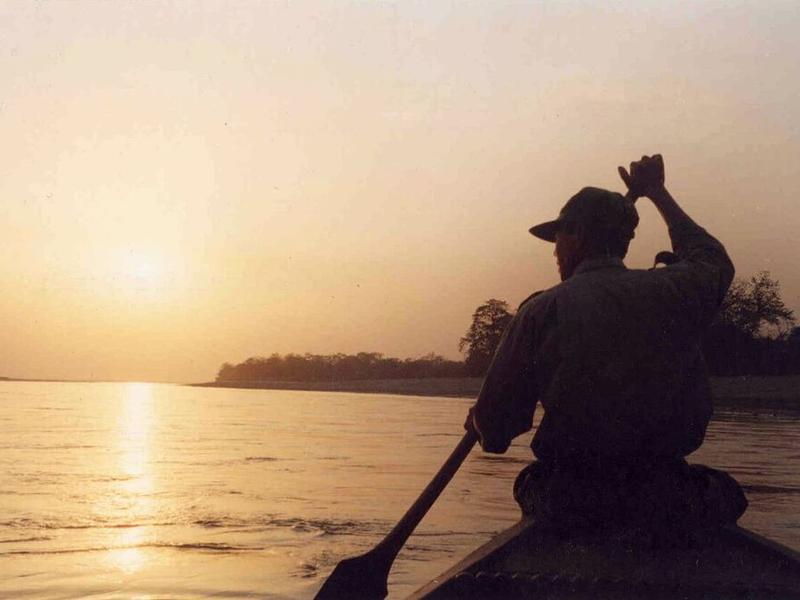 Man rowing boat at sunset