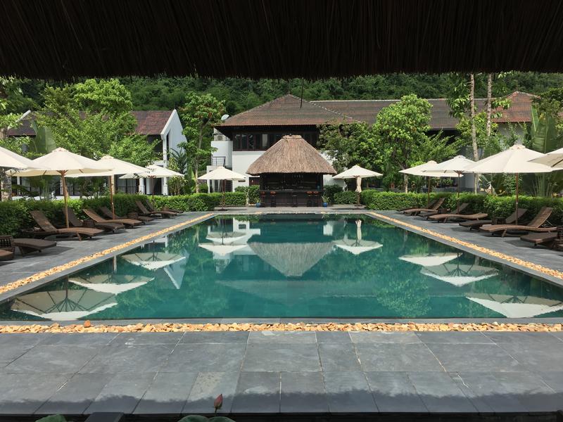Swimming pool and loungers at Aravinda Resort