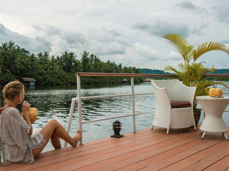 Woman sitting on a balcony at 4 Rivers Floating Lodge
